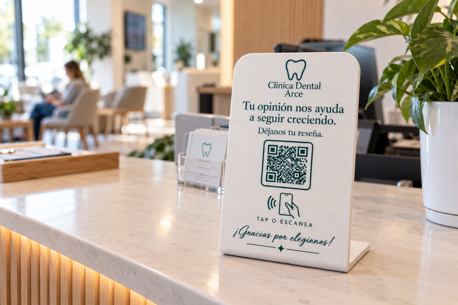 Placa NFC de reseñas blanca con detalles verde azulado en el mostrador de una clínica dental