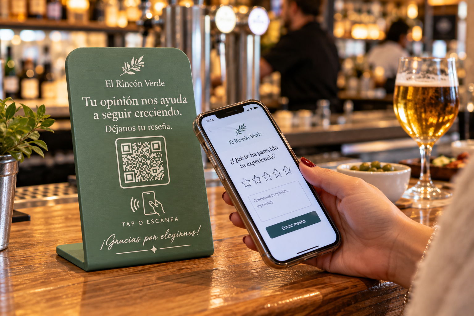 Mano acercando un smartphone a una placa NFC de reseñas verde salvia en la barra de un bar